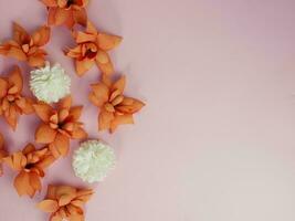 Greeting card background, orange dried flowers on pink. Flat lay, top view, copy space photo