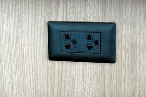 Black electrical plug on the wooden background with copy space. photo