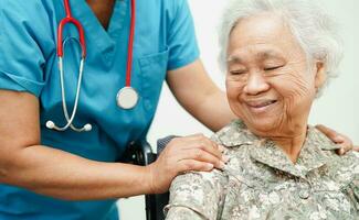 Doctor help Asian elderly woman disability patient sitting on wheelchair in hospital, medical concept. photo