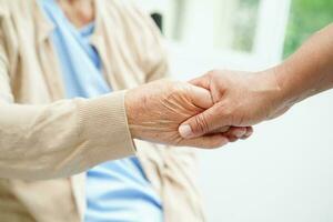 Doctor holding hands Asian elderly woman patient, help and care in hospital. photo