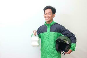 Portrait of Asian online taxi driver wearing green jacket and helmet holding food wrapped in foam plastic box. Isolated image on white background photo