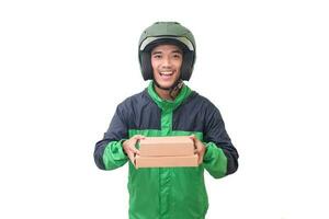 Portrait of Asian online courier driver wearing green jacket and helmet delivering package and box for customer. Isolated image on white background photo