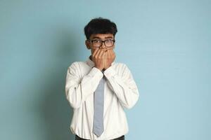 Indonesian senior high school student wearing white shirt uniform with gray tie covering his face with hands. Isolated image on white background photo