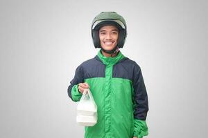 Portrait of Asian online taxi driver wearing green jacket and helmet holding food wrapped in foam plastic box. Isolated image on white background photo