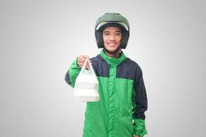 Portrait of Asian online taxi driver wearing green jacket and helmet holding food wrapped in foam plastic box. Isolated image on white background photo