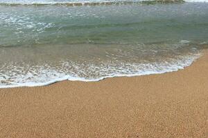 calmante olas estrellarse en playa foto