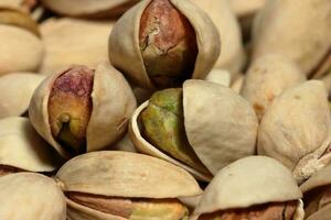 Pistachio nuts close up macro photo. Pistachios on texture background. Tasty pistachios as background photo