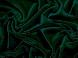 textura de tela de terciopelo verde utilizada como fondo. fondo de tela verde vacío de material textil suave y liso. hay espacio para el texto. foto