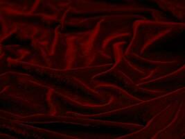 textura de tela de terciopelo rojo utilizada como fondo. fondo de tela roja vacía de material textil suave y liso. hay espacio para el texto.. foto