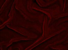 textura de tela de terciopelo rojo utilizada como fondo. fondo de tela roja vacía de material textil suave y liso. hay espacio para el texto.. foto