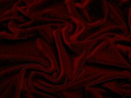 textura de tela de terciopelo rojo utilizada como fondo. fondo de tela roja vacía de material textil suave y liso. hay espacio para el texto.. foto