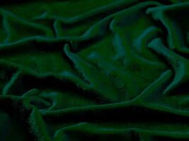 textura de tela de terciopelo verde utilizada como fondo. fondo de tela verde vacío de material textil suave y liso. hay espacio para el texto. foto