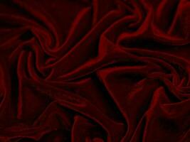 textura de tela de terciopelo rojo utilizada como fondo. fondo de tela roja vacía de material textil suave y liso. hay espacio para el texto.. foto