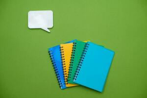 Collection different bright school stationery  and notebooks on green background, flat lay. Back to school concept. photo