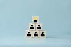 Concept and idea of leadership at the top with star best performance  and followers in black wooden blocks. The top of square wooden toy blocks is leader of below representing as followers. photo