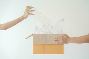 People launch a campaign to recycle used empty plastic bottles. Hands holding cardboard box full with plastic bottle ready to recycle. Concept of reuse, reduce, recycle to save the environment photo