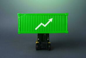 Green shipping container with up arrow. Increase in imports and exports of goods. Trade traffic increasing. Production rise. Growing transportation prices. Growth in profits. High shipping rates. photo