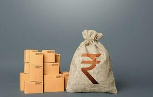 Boxes and indian rupee money bag. The concept of trade in goods and production. Profit from trading. GDP economy. Import export. Warehousing logistics. Business industry. Delivering. photo