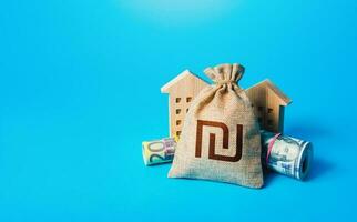 Houses and israeli shekel money bag. Building up capital, saving from inflation risks. Real estate. Savings. Declaration, taxes payment. Bookkeeping, accounting. Asset, financial resource management. photo