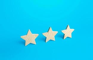 Three stars on a blue background. Rating evaluation concept. Service quality. Buyer feedback. High satisfaction. Popularity rating of a restaurant, hotel or mobile applications. Good reputation status photo