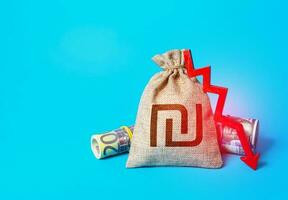 Israeli shekel money bag and arrow down. Falling economy. Decrease in interest rate deposit rate. Inflation. Drop in profits. Low real incomes, economic difficulties. Unprofitability photo