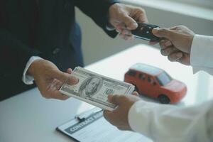 Closeup asian male people car salesman or sales manager offers to sell a car and explains and reads the terms of signing a car contract and insurance. photo