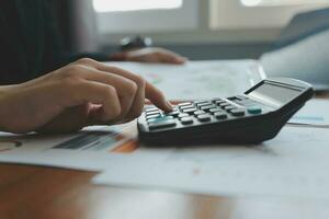 Group of confident business people point to graphs and charts to analyze market data, balance sheet, account, net profit to plan new sales strategies to increase production capacity. photo