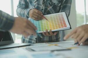 Close up ux developer and ui designer brainstorming about mobile app interface wireframe design on table with customer breif and color code at modern office.Creative digital development agency photo
