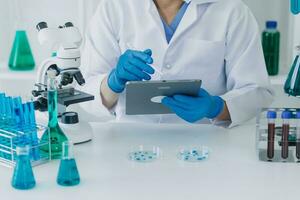 Medical Development Laboratory Caucasian Female Scientist Looking Under Microscope, Analyzes Petri Dish Sample. Specialists Working on Medicine, Biotechnology Research in Advanced Pharma Lab photo