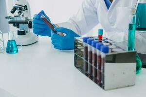 hand of scientist with test tube and flask in medical chemistry lab blue banner background photo