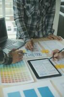 Close up ux developer and ui designer brainstorming about mobile app interface wireframe design on table with customer breif and color code at modern office.Creative digital development agency photo