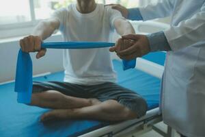 Doctor or physical therapist examines back pain and spinal area to give advice within the rehabilitation center. photo