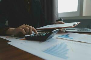 Group of confident business people point to graphs and charts to analyze market data, balance sheet, account, net profit to plan new sales strategies to increase production capacity. photo