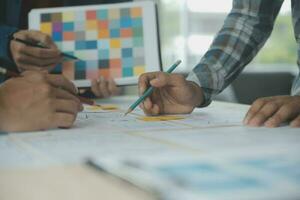 Close up ux developer and ui designer brainstorming about mobile app interface wireframe design on table with customer breif and color code at modern office.Creative digital development agency photo