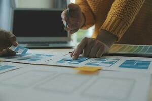 Close up ux developer and ui designer brainstorming about mobile app interface wireframe design on table with customer breif and color code at modern office.Creative digital development agency photo