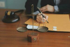 Business and lawyers discussing contract papers with brass scale on desk in office. Law, legal services, advice, justice and law concept picture with film grain effect photo