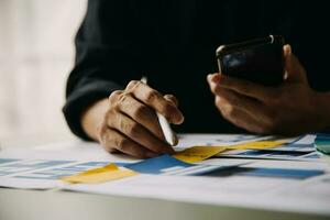 Close up ux developer and ui designer brainstorming about mobile app interface wireframe design on table with customer breif and color code at modern office.Creative digital development agency photo