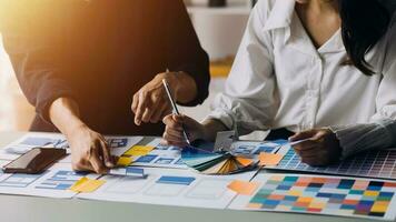 Close up ux developer and ui designer brainstorming about mobile app interface wireframe design on table with customer breif and color code at modern office.Creative digital development agency photo