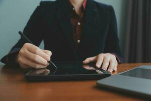 Asian Businesswoman Using laptop computer and working at office with calculator document on desk, doing planning analyzing the financial report, business plan investment, finance analysis concept. photo