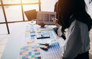 Close up ux developer and ui designer brainstorming about mobile app interface wireframe design on table with customer breif and color code at modern office.Creative digital development agency photo