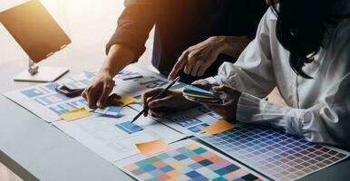 Close up ux developer and ui designer brainstorming about mobile app interface wireframe design on table with customer breif and color code at modern office.Creative digital development agency photo