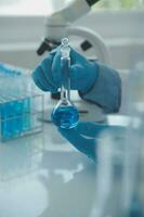 biochemical research scientist team working with microscope for coronavirus vaccine development in pharmaceutical research labolatory, selective focus photo