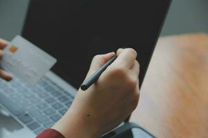 Close up of woman hand using credit card and laptop for payment and online shopping, Online shopping, payments digital banking, E-commerce concept. photo