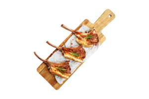 Grilled rack of lamb served on a wooden board with transparent background png