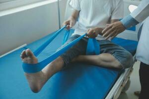 Doctor or physical therapist examines back pain and spinal area to give advice within the rehabilitation center. photo