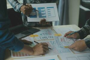 Close up ux developer and ui designer brainstorming about mobile app interface wireframe design on table with customer breif and color code at modern office.Creative digital development agency photo