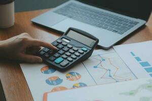 Group of confident business people point to graphs and charts to analyze market data, balance sheet, account, net profit to plan new sales strategies to increase production capacity. photo