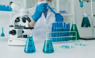 hand of scientist with test tube and flask in medical chemistry lab blue banner background photo