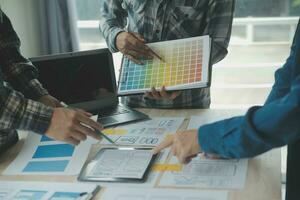 Close up ux developer and ui designer brainstorming about mobile app interface wireframe design on table with customer breif and color code at modern office.Creative digital development agency photo