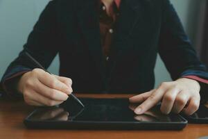 Asian Businesswoman Using laptop computer and working at office with calculator document on desk, doing planning analyzing the financial report, business plan investment, finance analysis concept. photo